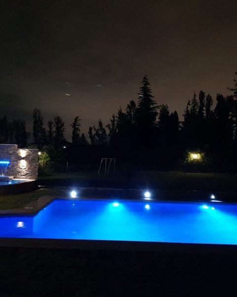 Piscina con iluminación LED azul de noche